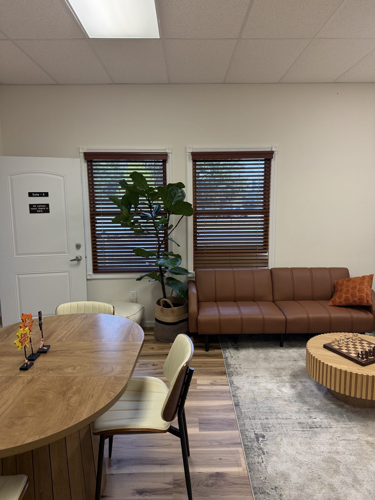 Client lounge with a wooden table and chairs beside the sofa