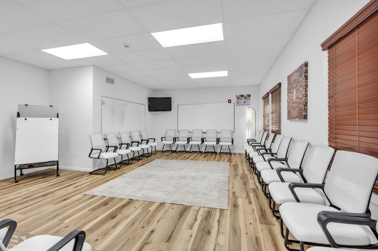 Group therapy room with chairs arranged around the walls and a whiteboard
