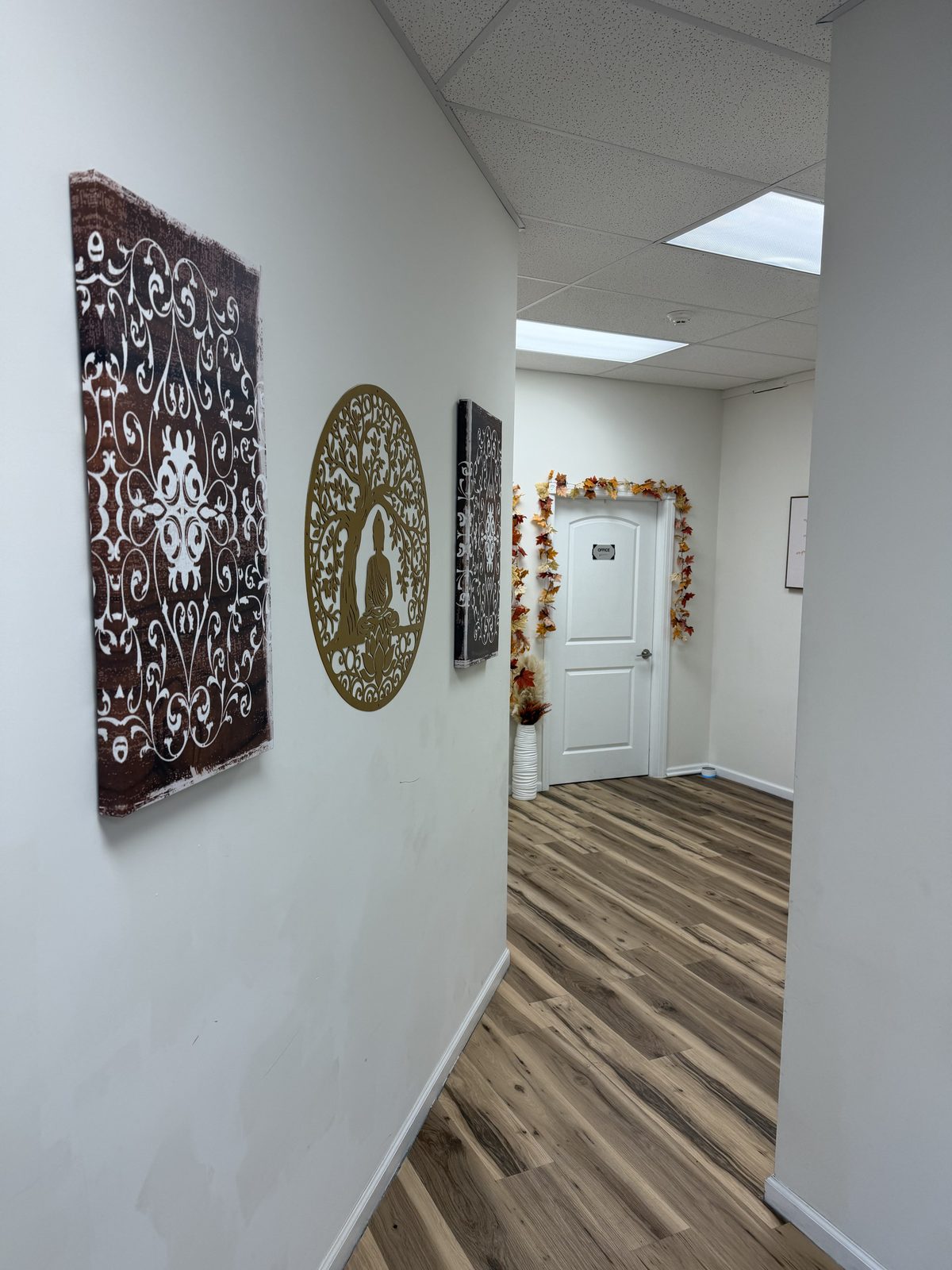 Hallway with wall art leading toward the offices