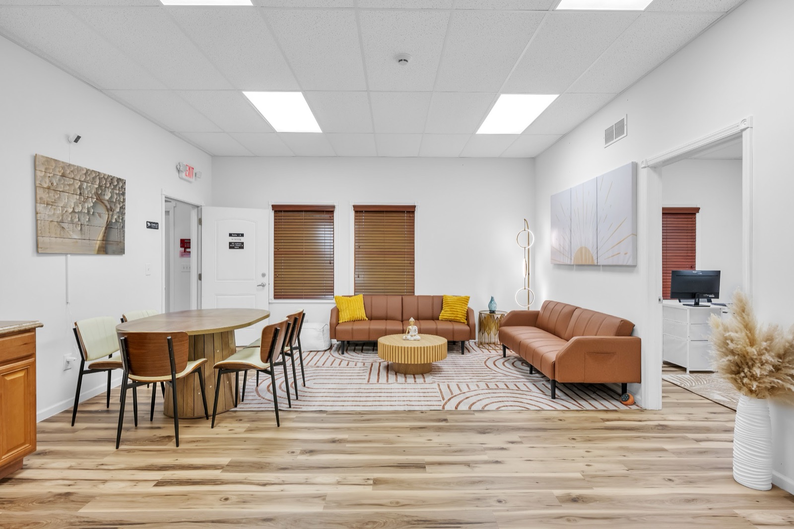 Client lounge with two sofas, an oval table with chairs, and a round coffee table