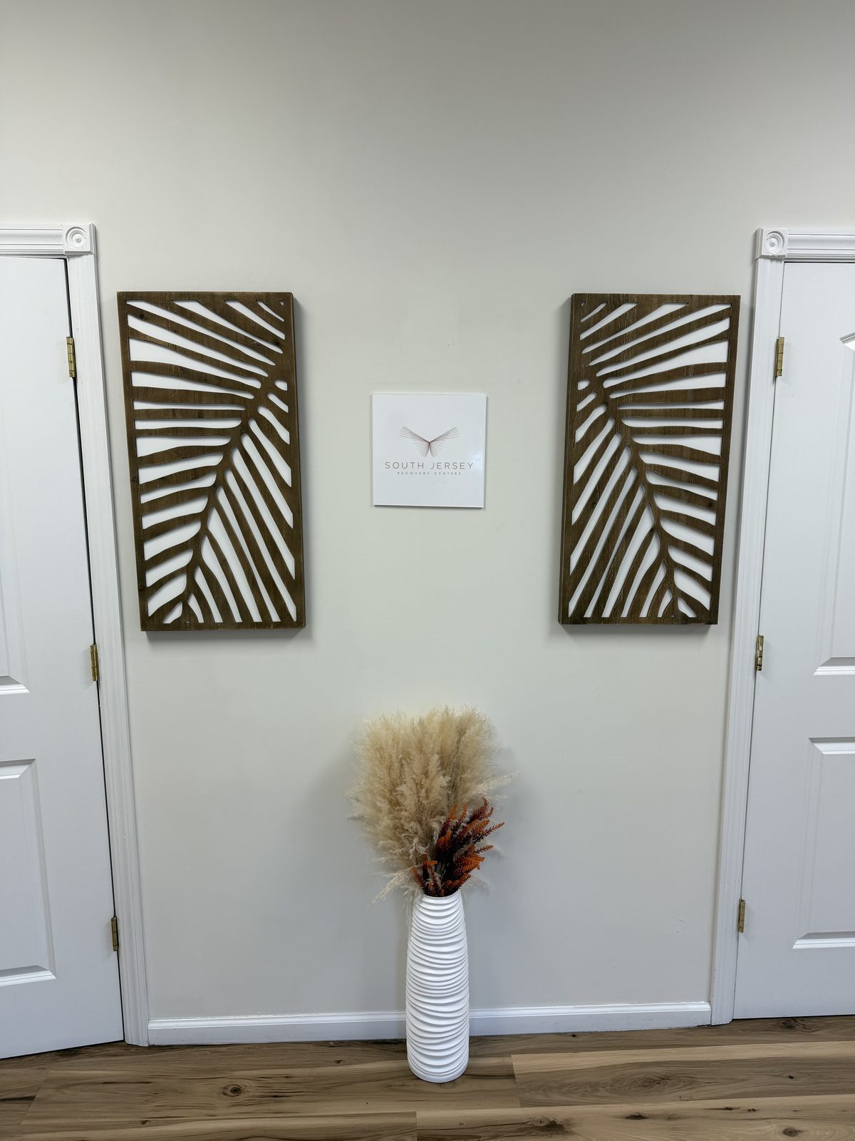 Hallway wall with the program logo between two carved wood panels