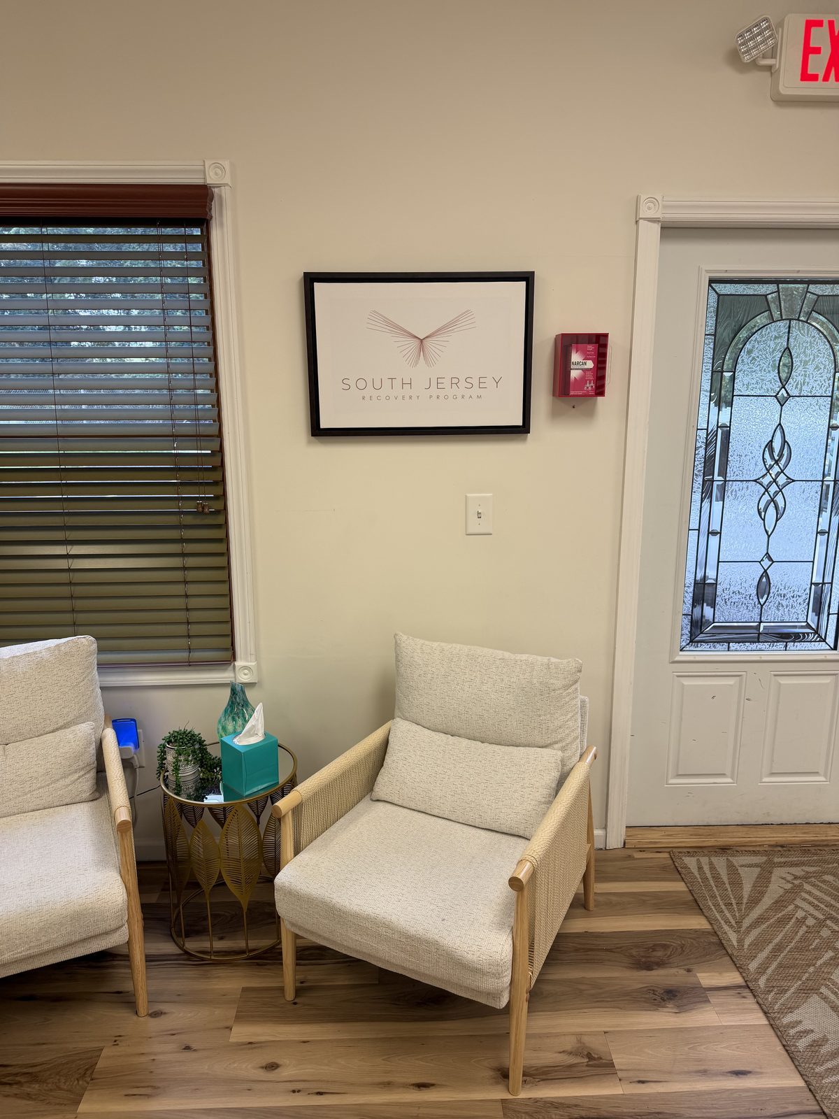 Waiting area with two armchairs beneath the South Jersey Recovery Program sign